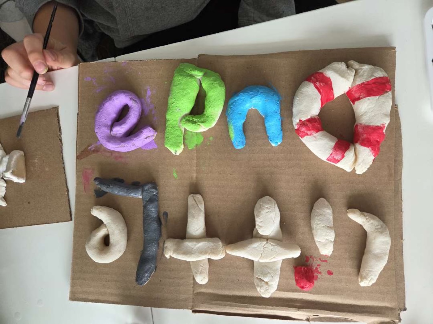 Hand-rolled salt-dough letters and shapes painted in bright colours